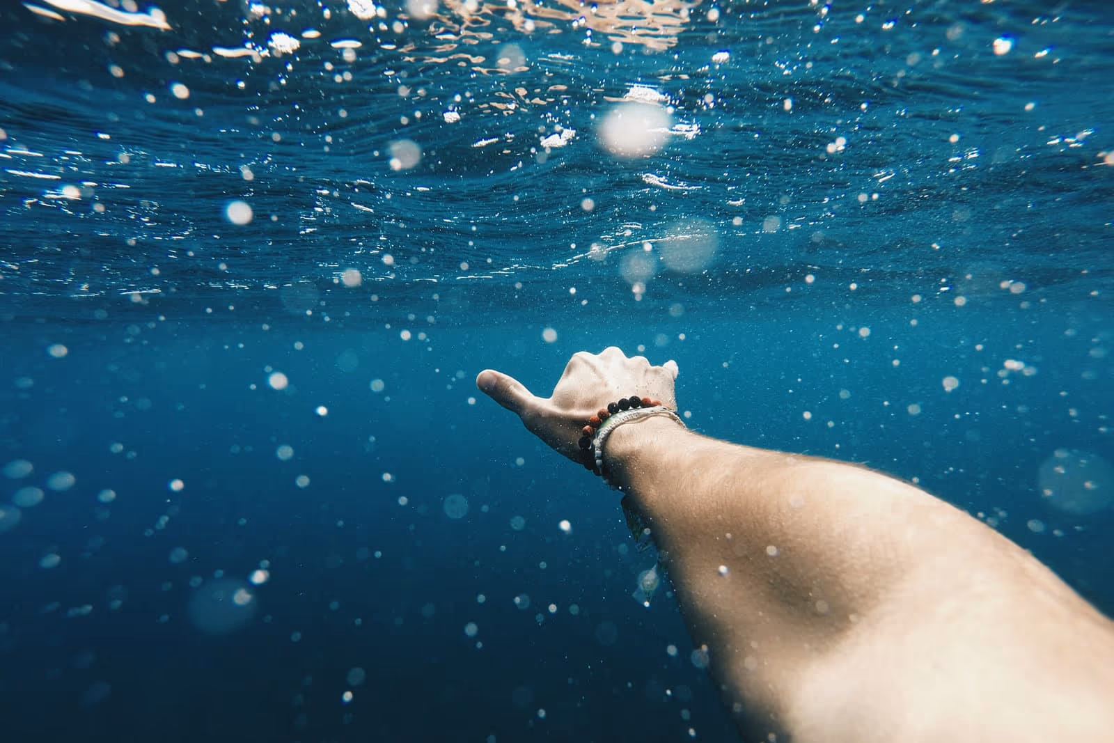 Ponto de vista de nadador sob a água estendendo a mão — liberdade para nadar sem óculos.